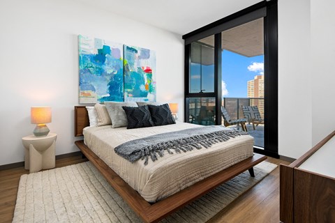 A bedroom with a large bed and a painting on the wall.