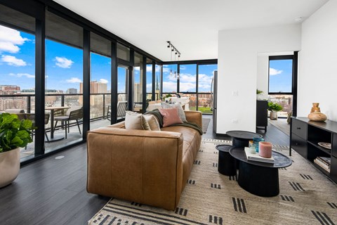 A living room with a brown couch and a view of the city.