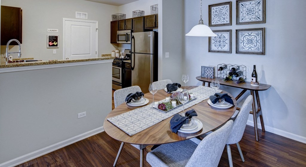 a dining area with a table and chairs and a kitchen