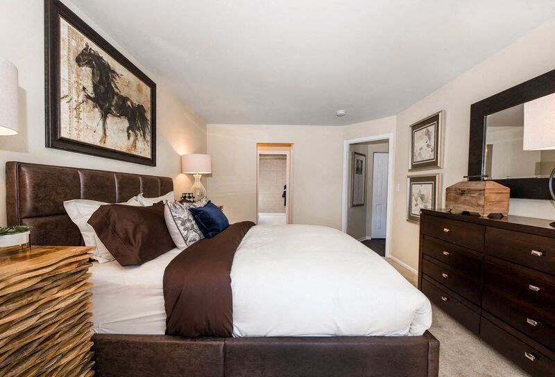 a bedroom with a large bed and a large mirror