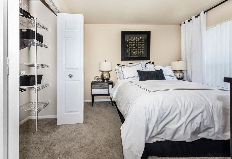 a bedroom with a white bed and a closet