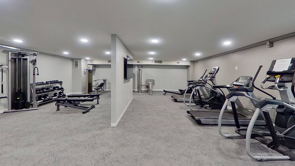 a gym with cardio equipment and weights in a building
