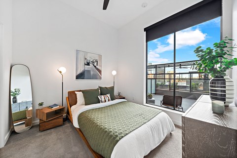A bedroom with a large bed and a view of the city.