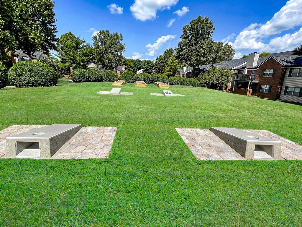 a park with benches and stone benches on the grass