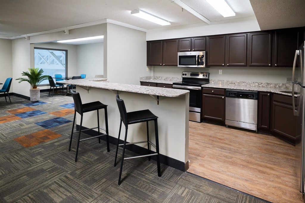 an open kitchen and living room with a large island with stools