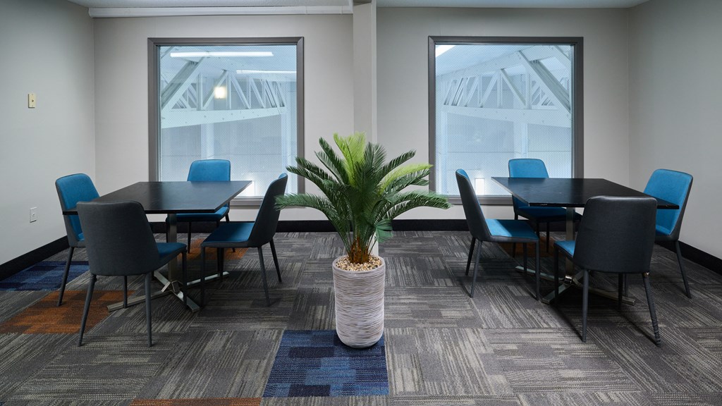 a conference room with tables and chairs and a palm tree