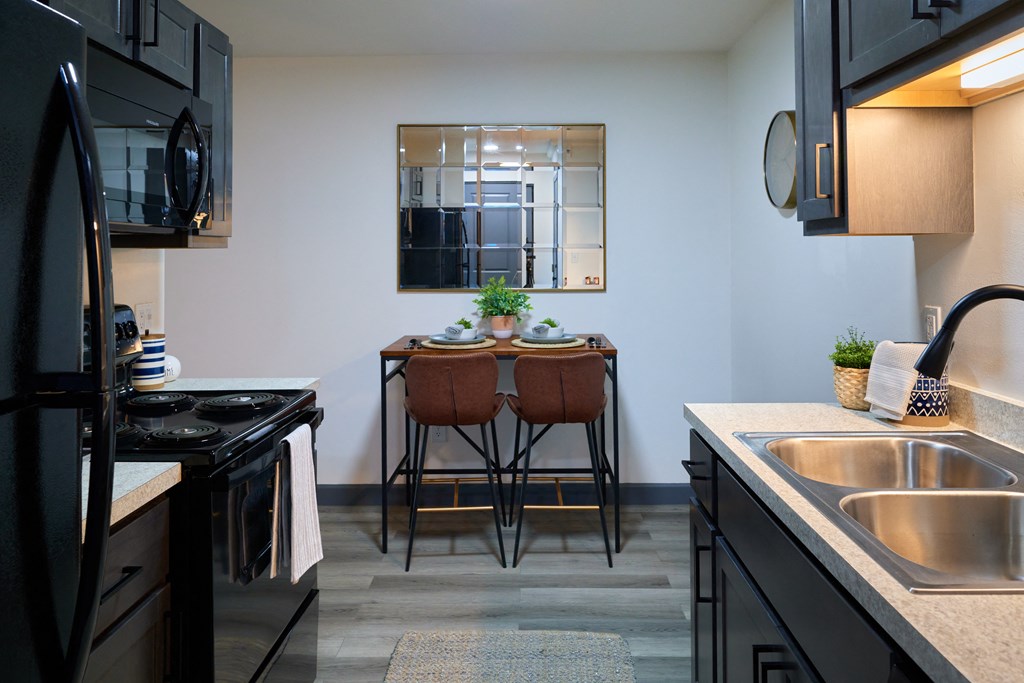 a kitchen and dining area with a table and chairs and a sink