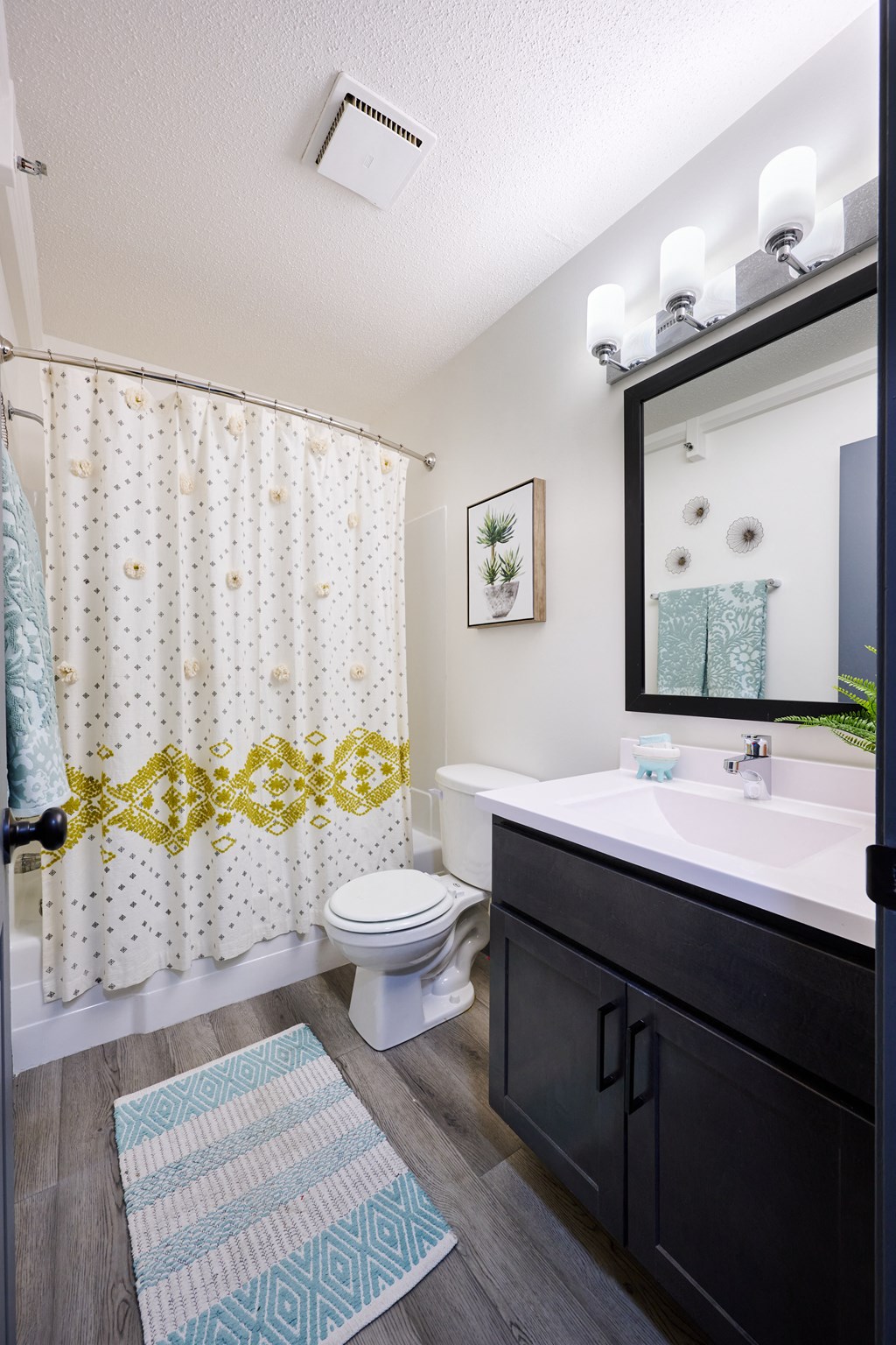 an open bathroom with a shower and a sink and a toilet