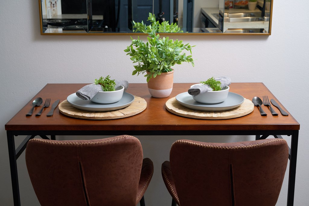 a wooden table with two plates and bowls on top of it
