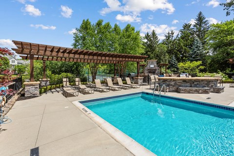 A swimming pool with a wooden pergola over it.