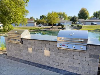 A stone wall with two built in BBQs.