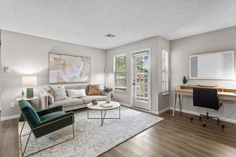 A living room with a green chair and a white couch.