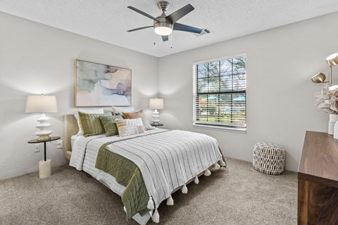 A bedroom with a large bed and a ceiling fan.