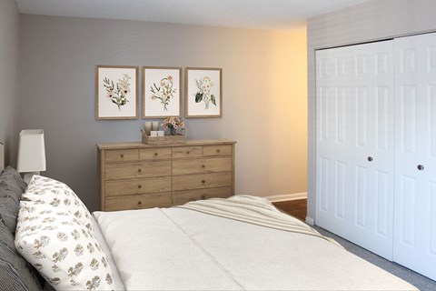 A bedroom with a bed, dresser, and three framed pictures on the wall.