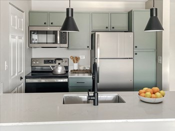 a kitchen with green cabinets and a white counter top - Photo Gallery 23