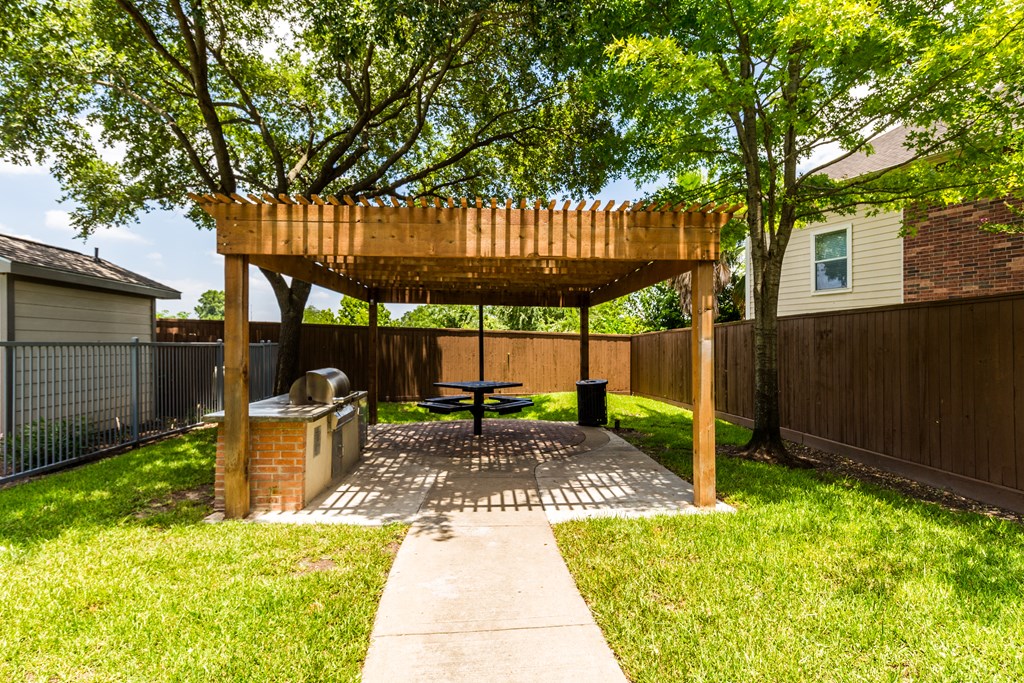 a picnic area in a backyard with a picnic table and awning
