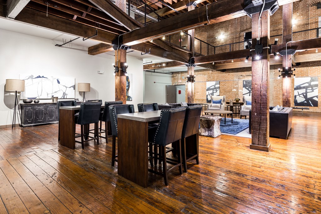 a dining room with tables and chairs in a large room with exposed brick