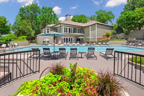 sundeck with lounge chairs by the pool with The Magnolia apartment building in the background