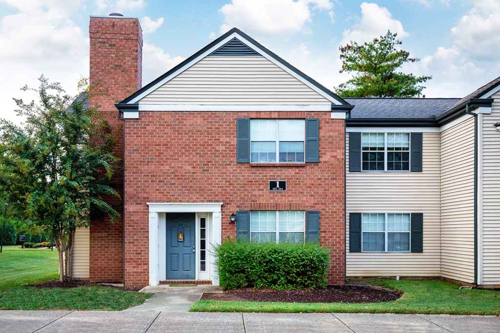 the front of a brick house with a blue door