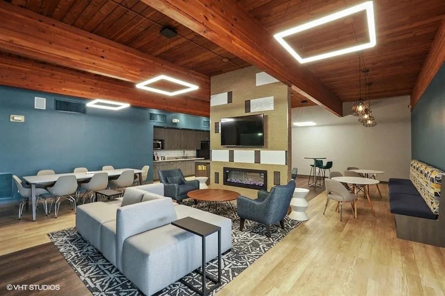 a living room with couches tables and chairs and a fireplace