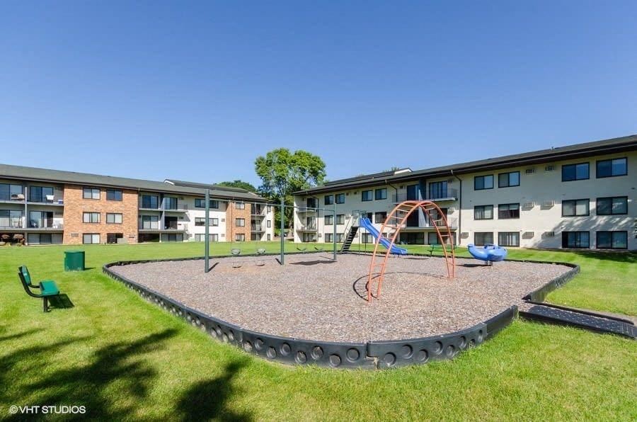 an outdoor playground in front of an apartment building