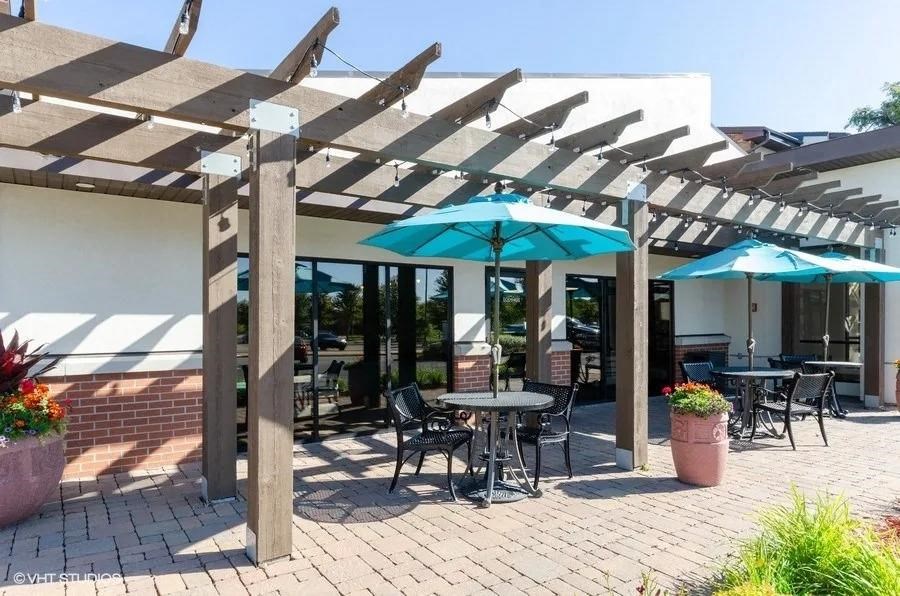 a patio with umbrellas and tables with chairs