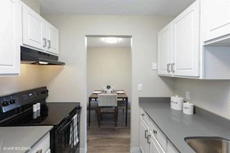 a kitchen with white cabinets and a dining room table