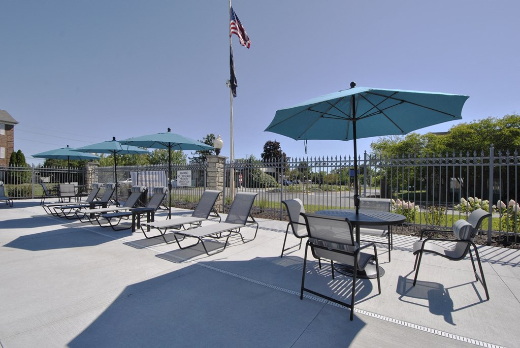 outdoor dining tables under blue umbrellas on The Maxwell sundeck