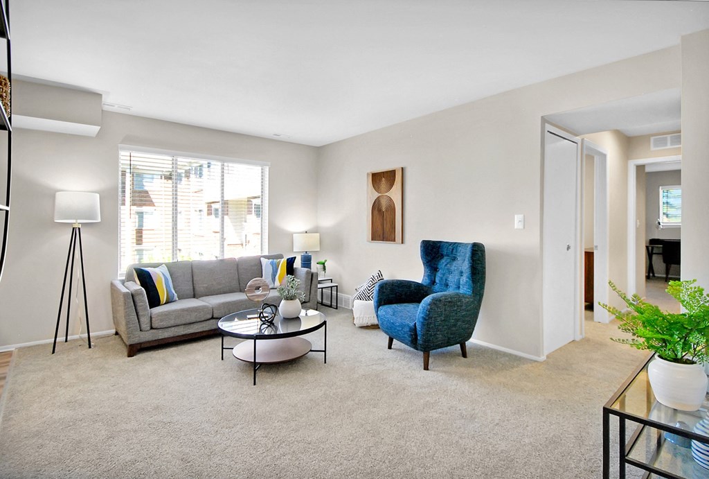 The Maxwell apartment living room with a grey couch and blue chair