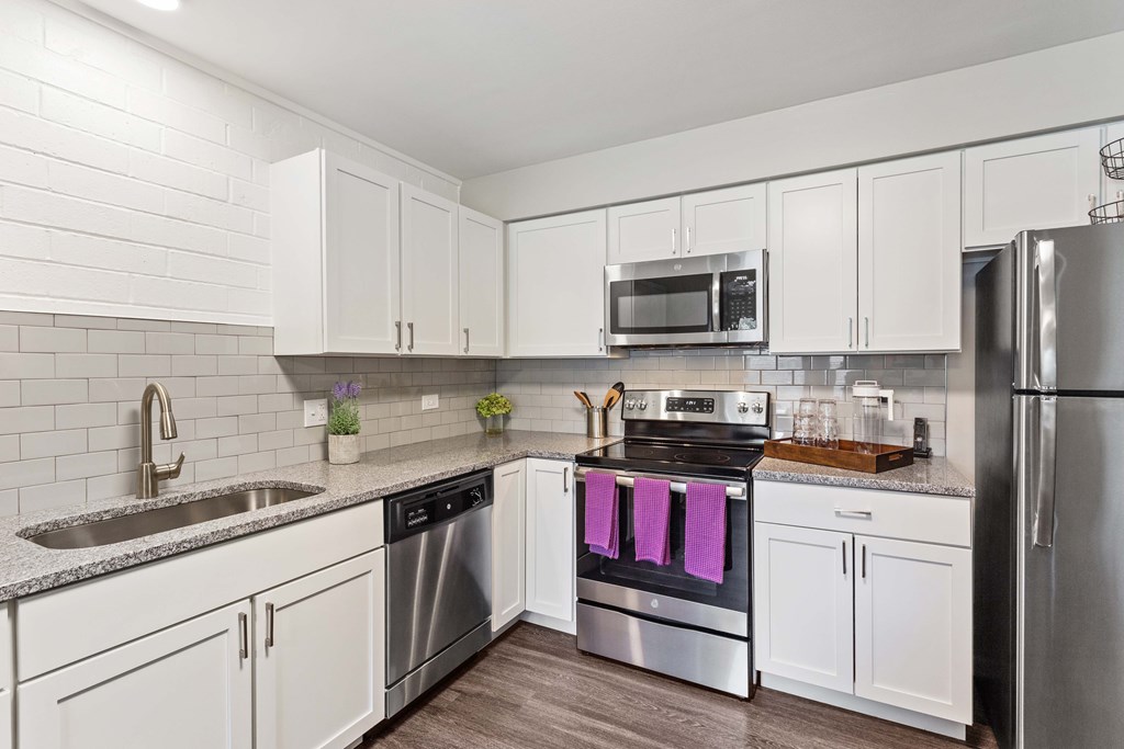 A kitchen with white cabinets and stainless steel appliances.