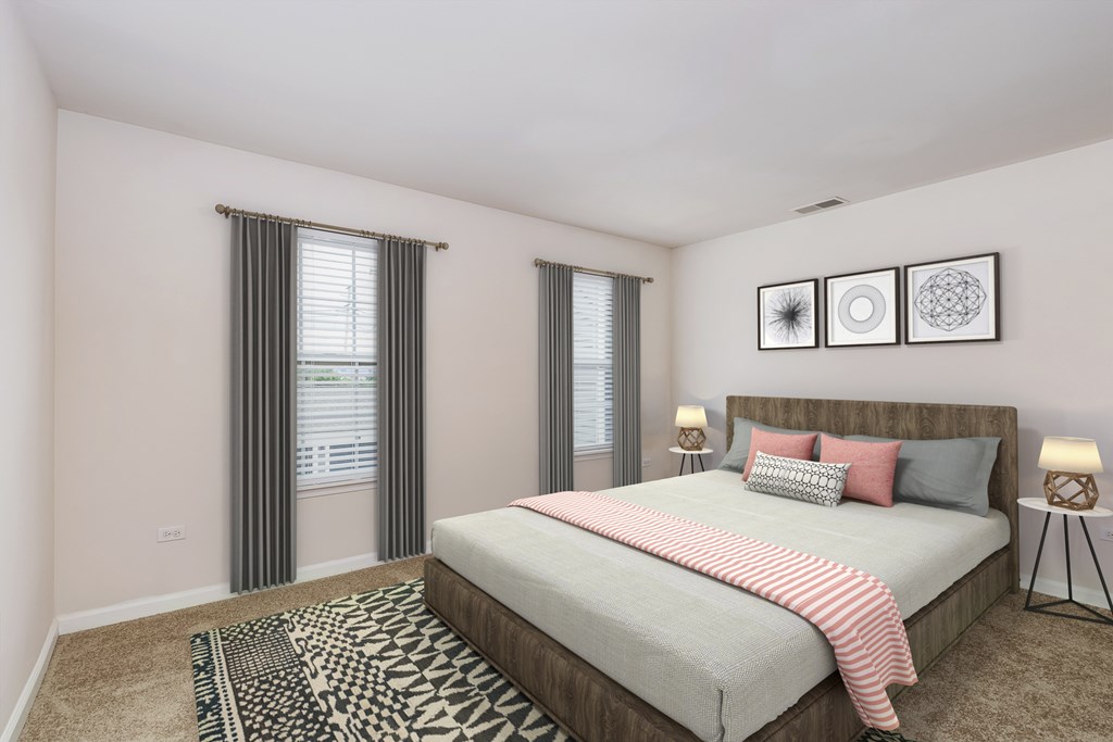 A bedroom with a large bed and two lamps.