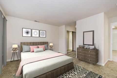 A bedroom with a large bed, a dresser, and a rug.