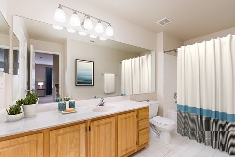 A bathroom with a white counter top and a white toilet.