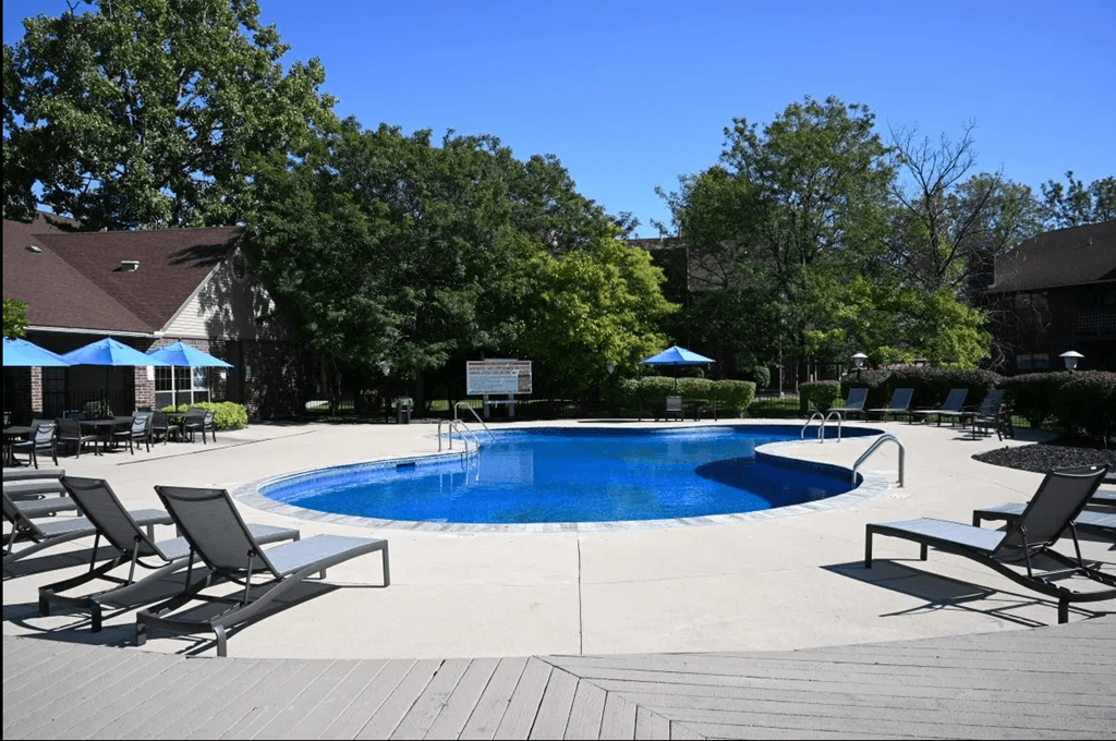 the pool is surrounded by chairs and umbrellas