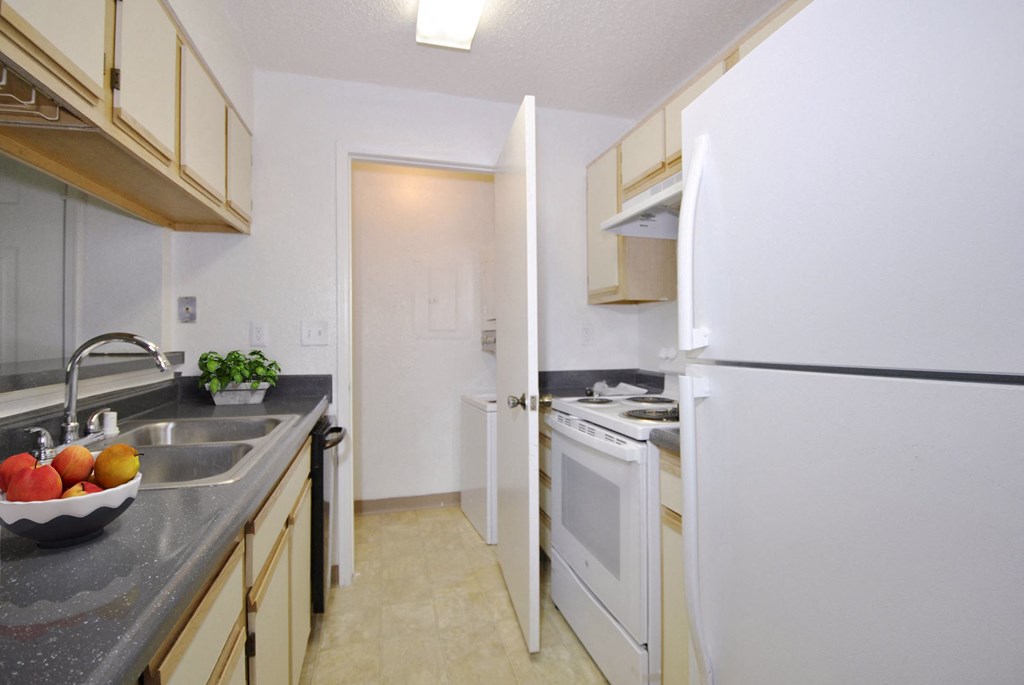 a kitchen with white appliances and a sink and a refrigerator