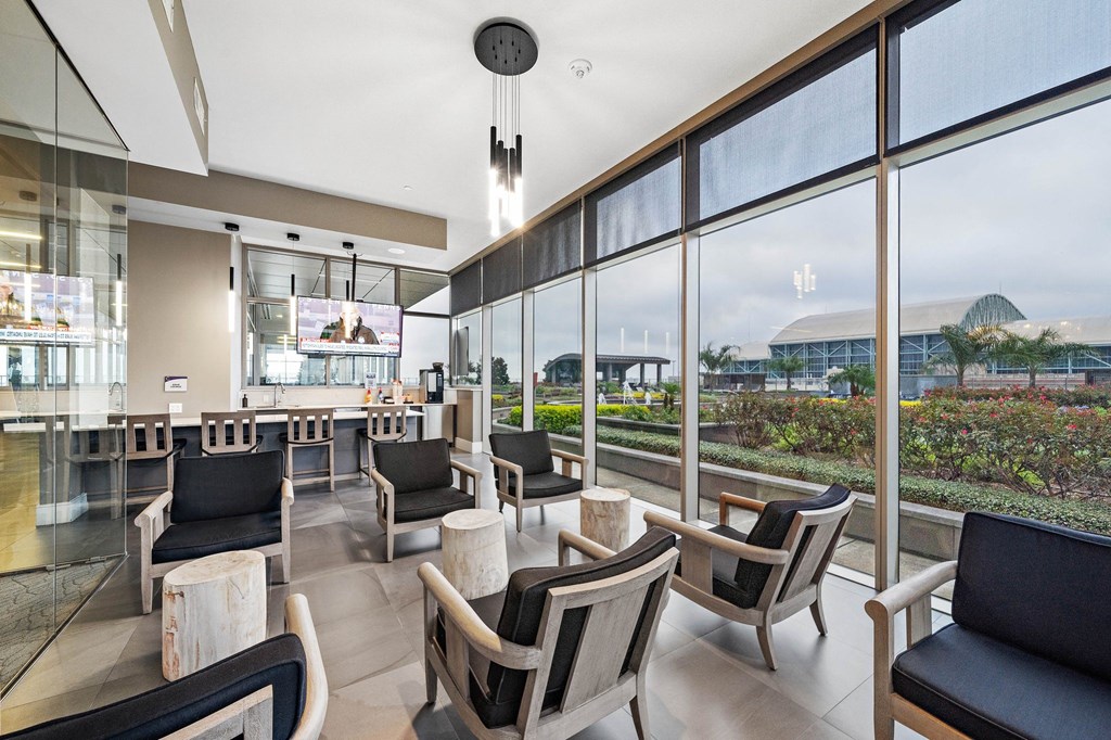 a lobby with chairs and tables and large windows