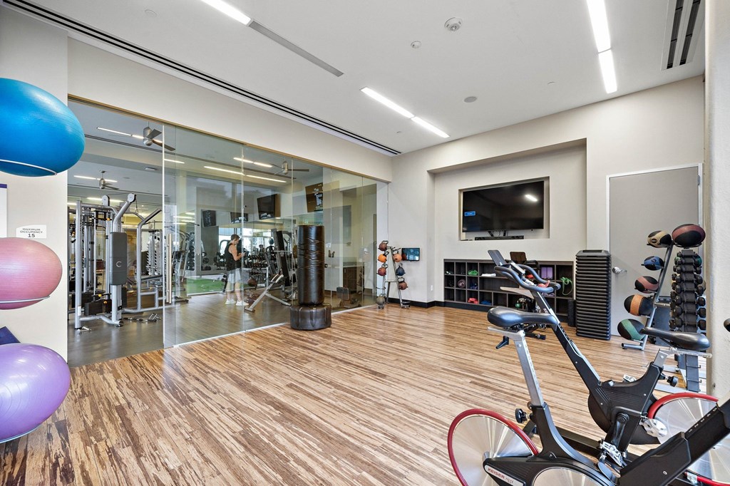 a gym with exercise equipment and a tv on the wall