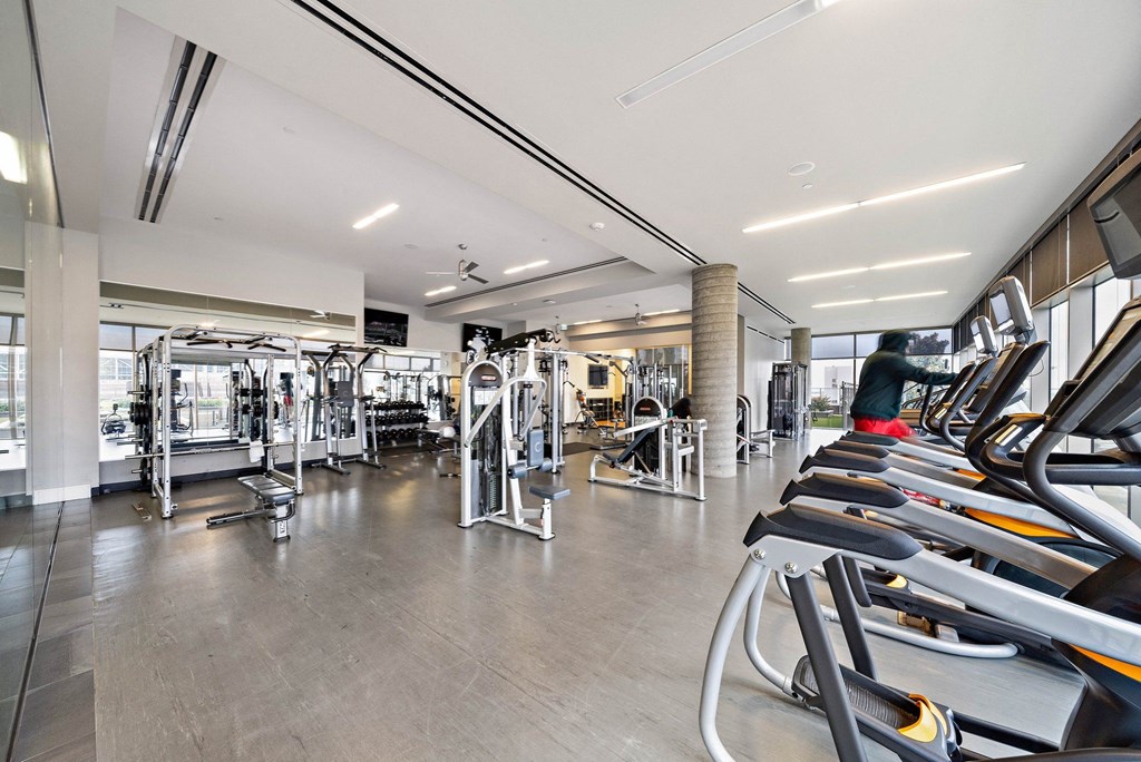 a gym with cardio equipment and people in it