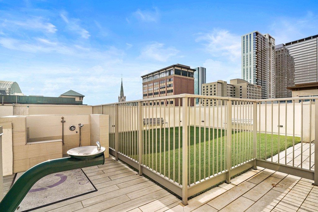 a balcony with a green lawn and a fence