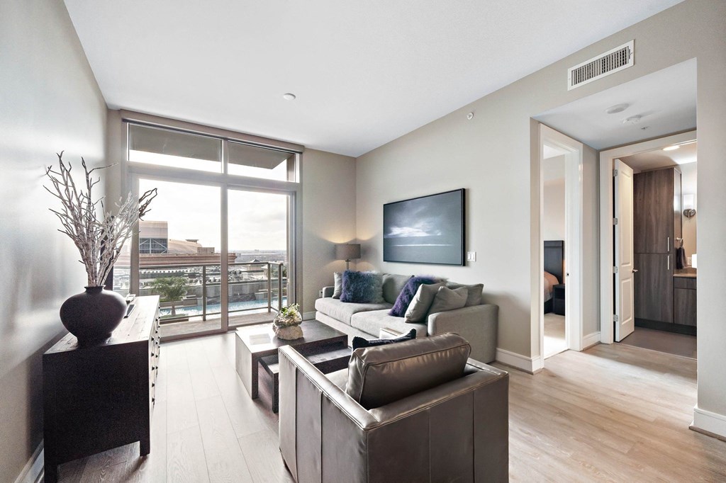 a living room with a couch and a chair and a large window