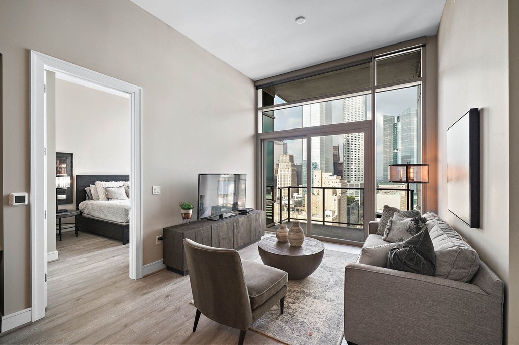 a living room with a large window and a view of a bedroom