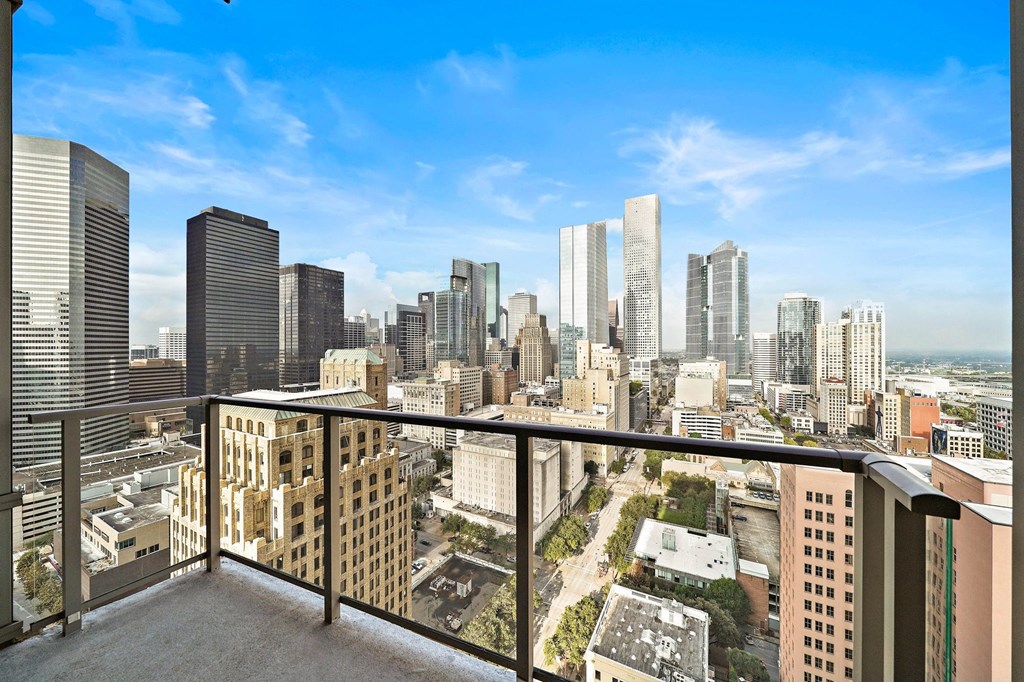 a view of the city skyline from a balcony with a balcony railing