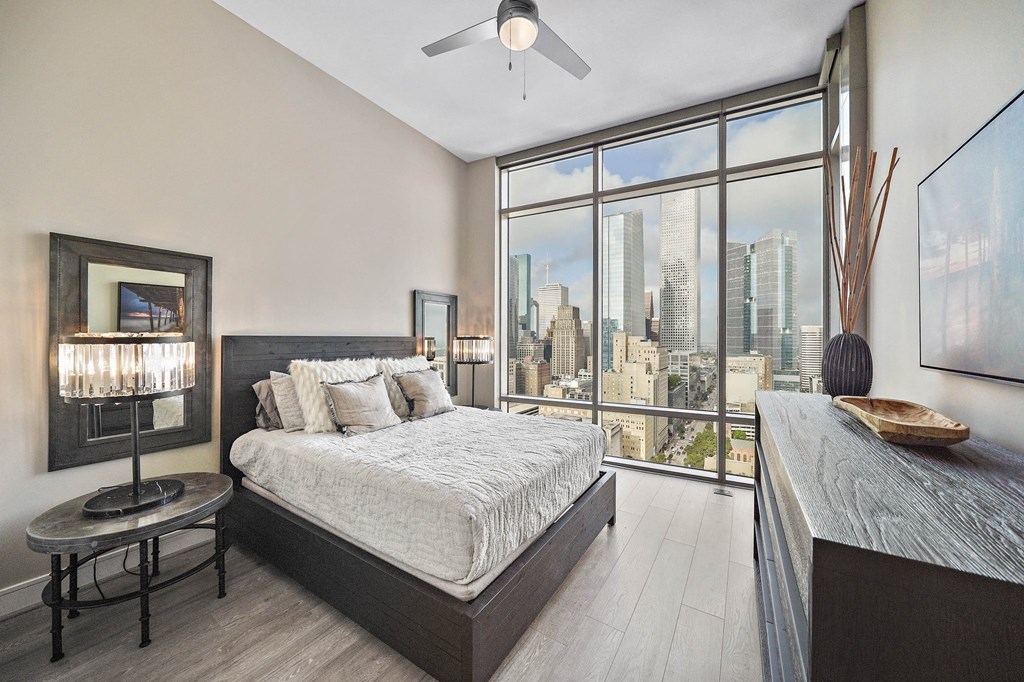 a bedroom with a bed and a view of the city
