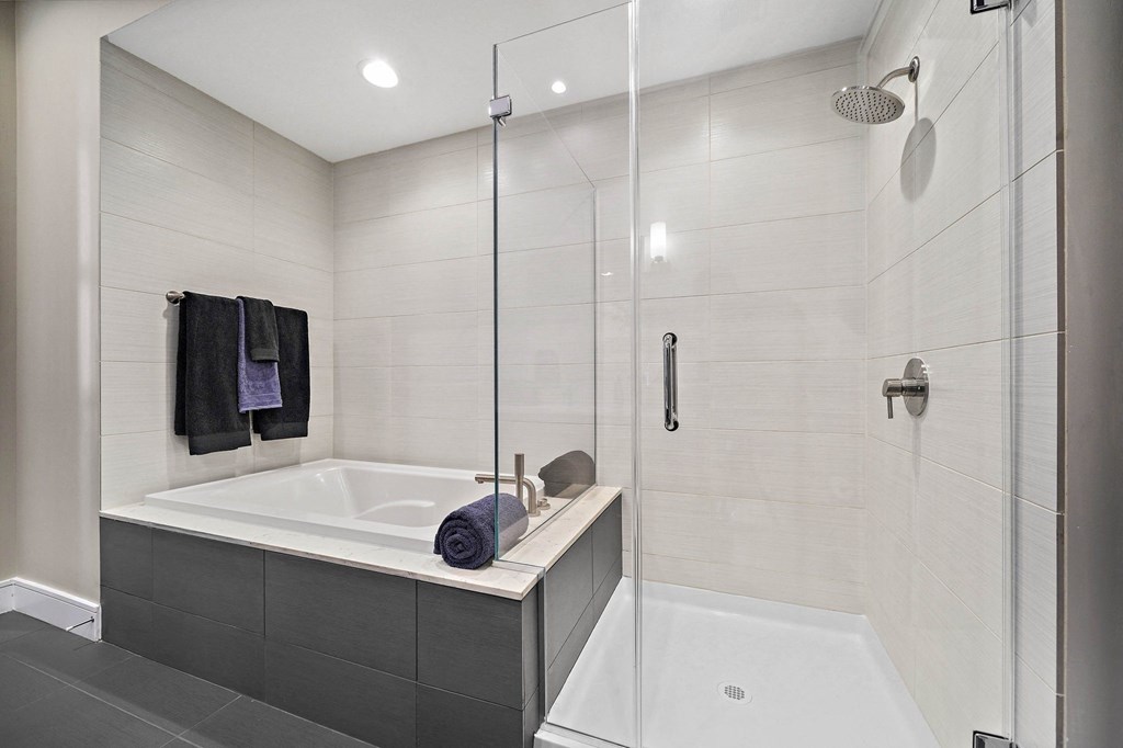a white bathroom with a tub and a shower
