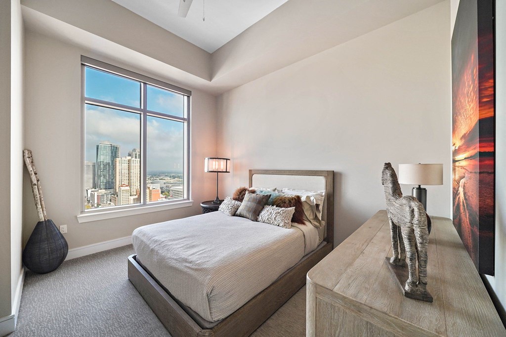 a bedroom with a bed and a view of the city