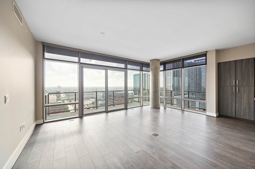 an empty living room with floor to ceiling windows and a city view