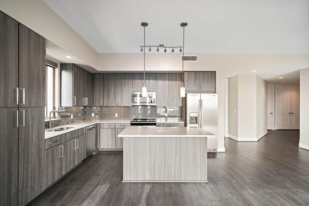 a large kitchen with a white island and wooden cabinets