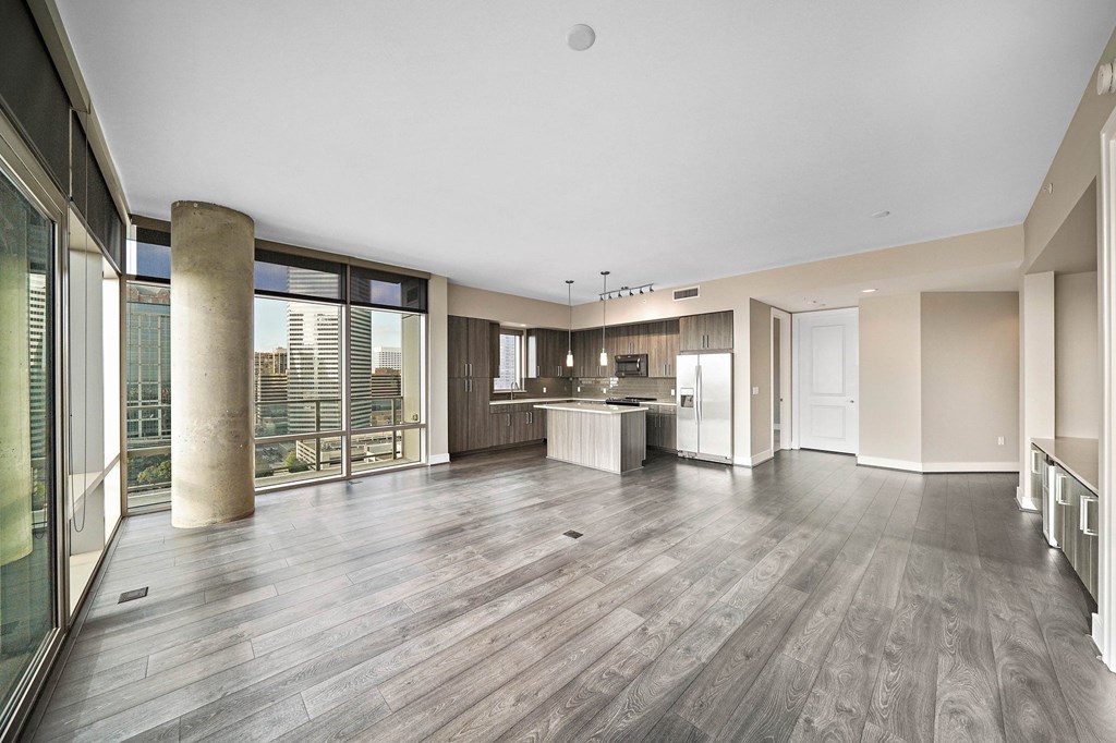 a large living room with a kitchen and a large window