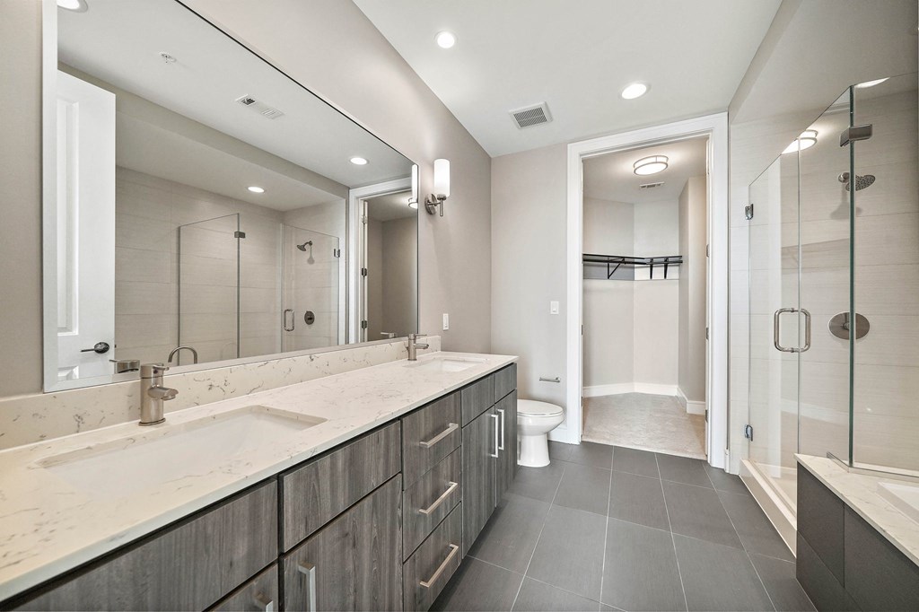 a bathroom with a large mirror and a sink and a shower