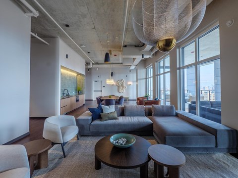 A modern living room with a large grey couch and a wooden coffee table.